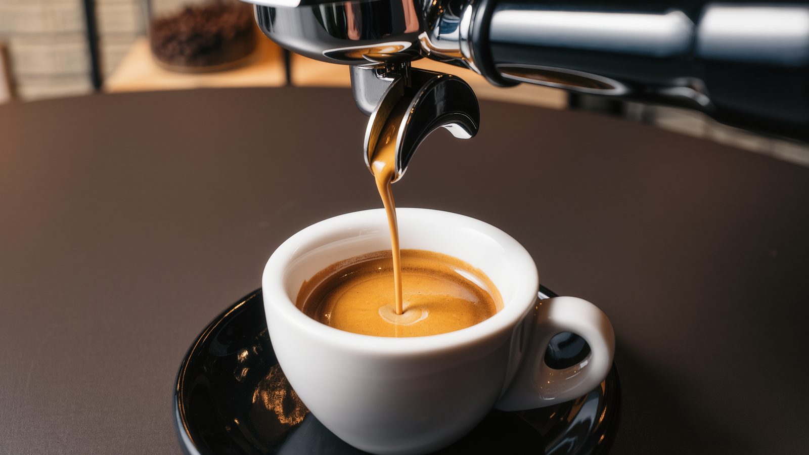 Espresso pouring from a portafilter into a ceramic cup